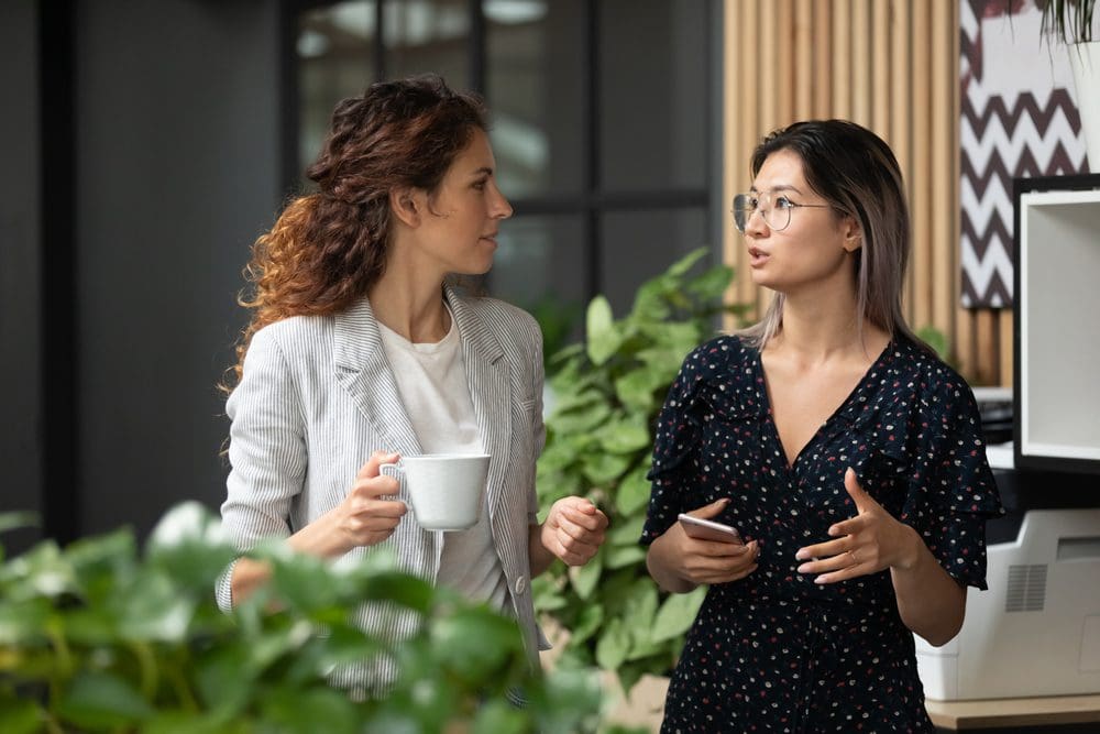 Two women having a conversation in an office.