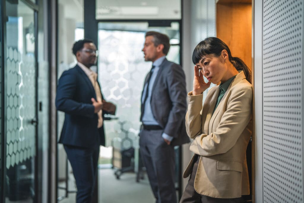 stressed businesswoman experiencing workplace bullying or burnout in office