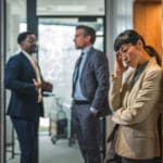stressed businesswoman experiencing workplace bullying or burnout in office